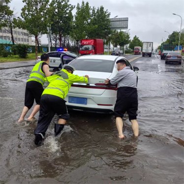 暴雨中温暖坚守——那一抹照进雨中的荧光绿