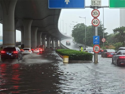 暖心一幕！青岛市市北交警大雨中背起学生趟水过马路